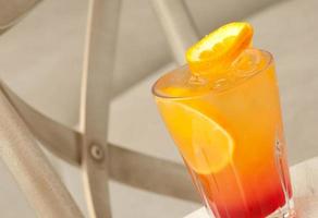 a glass with a drink on the table photo