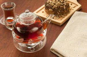Transparent glass teapot and cup with tea photo