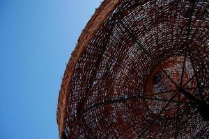 straw umbrella and blue sky on the beach photo