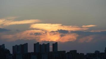 la hermosa vista de la puesta de sol con la silueta y el cielo de nubes coloridas en la ciudad foto