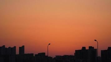 la hermosa vista de la puesta de sol con la silueta y el cielo de nubes coloridas en la ciudad foto