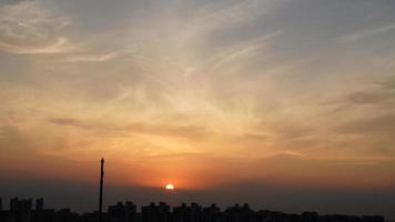 la hermosa vista de la puesta de sol con la silueta y el cielo de nubes coloridas en la ciudad foto