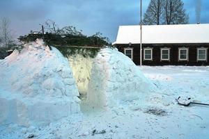 vista de una casa de nieve iglú construida en el pueblo de Rusia por la noche foto