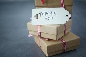 thank you note and gift box on black background photo