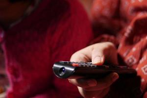 close up of women hand holding tv remote. photo