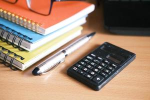 Close up of blue calculator and notepad on color background photo