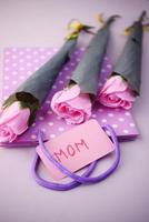 mother say concept with pink color rose flower and mom text on paper photo