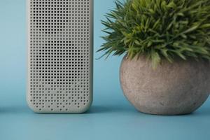 smart speaker and a plant on light green background photo