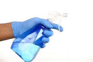 hand in blue rubber gloves holding spray bottle with copy space photo