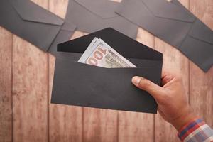 person hand putting cash in a envelope. photo