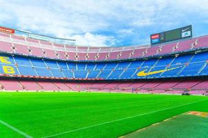 Barcelona, Spain, March 14, 2019 Camp Nou is the home stadium of football club Barcelona, the largest stadium in Spain. View of tribunes stands, green grass field and scoreboard from reserves bench. photo