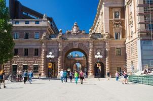 Sweden, Stockholm, May 30, 2018 People walk through Courtyard between arches of Parliament House Riksdag photo