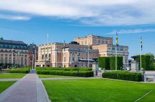 The Royal Swedish Opera house Kungliga Operan building with green bushes and grass lawn foreground photo