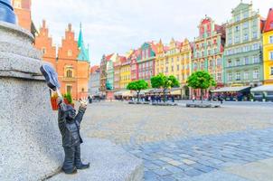 wroclaw, polonia, 7 de mayo de 2019 enano con guitarra en la plaza del mercado de rynek, edificios coloridos típicos, el famoso gnomo en miniatura de bronce con escultura de sombrero es un símbolo de wroclaw, el antiguo centro histórico de la ciudad