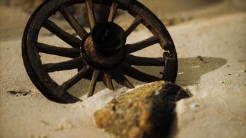 Large wooden wheel in the sand