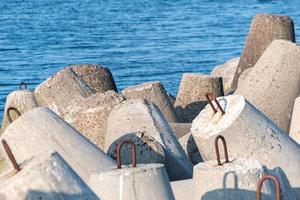 Breakwaters in sea, Beautiful sunset seascape with concrete tetrapodes for protect coastal structures from storm sea waves, effects of longshore drift and weather photo