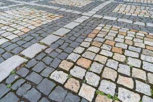 antiguo patrón de adoquines, textura de adoquines alemanes antiguos en el centro de la ciudad, pequeñas baldosas de granito, pavimentos grises antiguos. foto