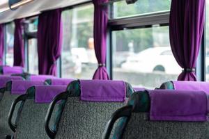 cómodos asientos traseros de autobús sin pasajeros, servicios de autocares interurbanos, nuevo interior de autobús con cinturones de seguridad en cada lugar. foto