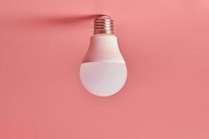 Light bulb, copy space. Energy saving minimal idea concept.Pink background. photo