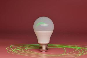 Energy saving light bulb, green laser beam around, copy space. Minimal idea concept. photo