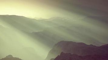 zwart rotsachtig bergsilhouet in diepe mist video