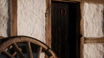 vecchia ruota di legno e porta nera alla casa bianca video