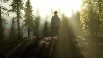 mujer joven de pie sola al aire libre con montañas de bosque salvaje