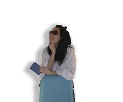Woman Traveler, Standing with a Blue Suitcase on a White Background, Copy Space. Lady Preparing for Vacation, Dreamily Looks Up, Dezhit Passport in Hand.