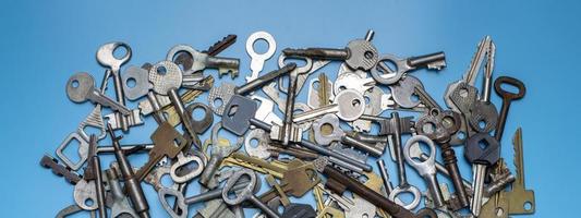 Keys set on blue background. Door lock keys and safes for property security and house protection. Different antique and new types of keys. photo