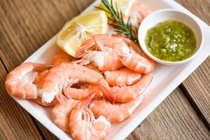 camarones frescos en una bandeja de plástico con limón, camarones hervidos, comida cocinada en el restaurante de mariscos foto