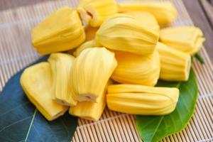 Ripe jackfruit peeled tropical fruit fresh from jackfruit tree, jackfruit on wooden with leaf background photo