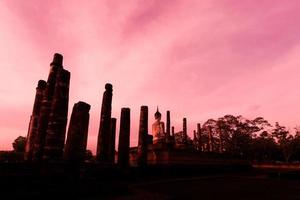 silueta estatua de buda en el templo wat mahathat en el parque histórico de sukhothai, provincia de sukhothai, tailandia. foto