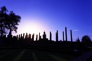 Silhouette Buddha Statue in Wat Mahathat Temple in Sukhothai Historical Park, Sukhothai Province, Thailand . photo