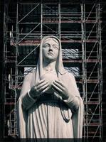 Mary is praying for peace with scaffold behind photo
