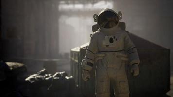 verlorener astronaut in der nähe von verlassenen industriegebäuden der alten fabrik