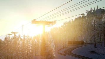 lege skilift. stoeltjeslift silhouet op hoge berg boven het bos bij zonsondergang video