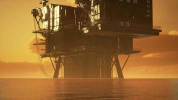 antiga plataforma de petróleo durante o pôr do sol no oceano video