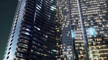 arquitectura nocturna de rascacielos con fachada de cristal