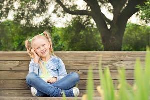 Cute little girl speaking on the phone and smiling photo