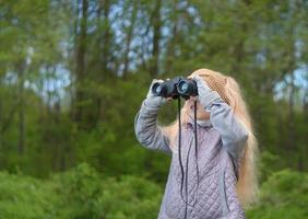 Girl looking through binoculars photo