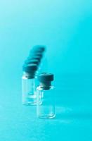 Several empty medical vials on blue background. Copy space. photo