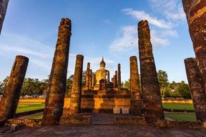 silueta estatua de buda en el templo wat mahathat en el parque histórico de sukhothai, provincia de sukhothai, tailandia. foto