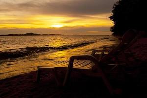 Colorful sunset over sea Pataya beach Thailand with beach chair photo