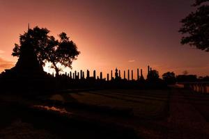 Silhouette Buddha Statue in Wat Mahathat Temple in Sukhothai Historical Park, Sukhothai Province, Thailand . photo