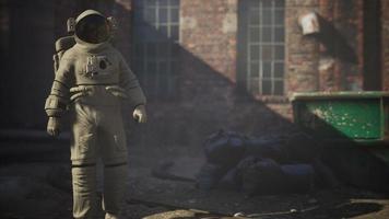 astronaute perdu près des bâtiments industriels abandonnés de l'ancienne usine