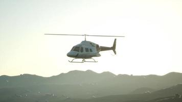 Hélicoptère volant au ralenti extrême 8k et ciel coucher de soleil video