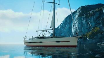 yacht in mare con isola rocciosa verdeggiante video