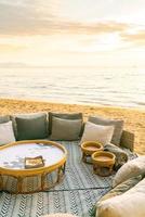 Almohadas en la tumbona del patio al aire libre en la playa con la hora del atardecer foto