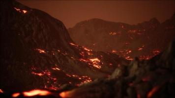 röd orange levande smält lava som rinner ut på grå lavafält och glänsande stenig mark video