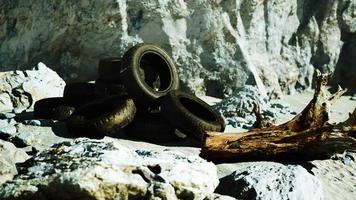 old tires overgrown embedded in the sand video